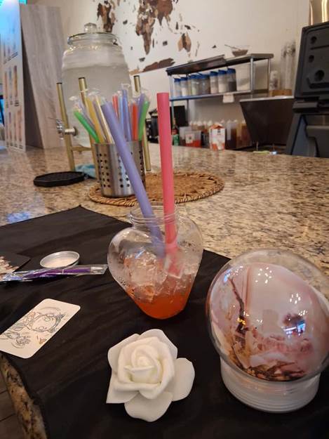 A glass vase with straws and a rose on a table

AI-generated content may be incorrect.